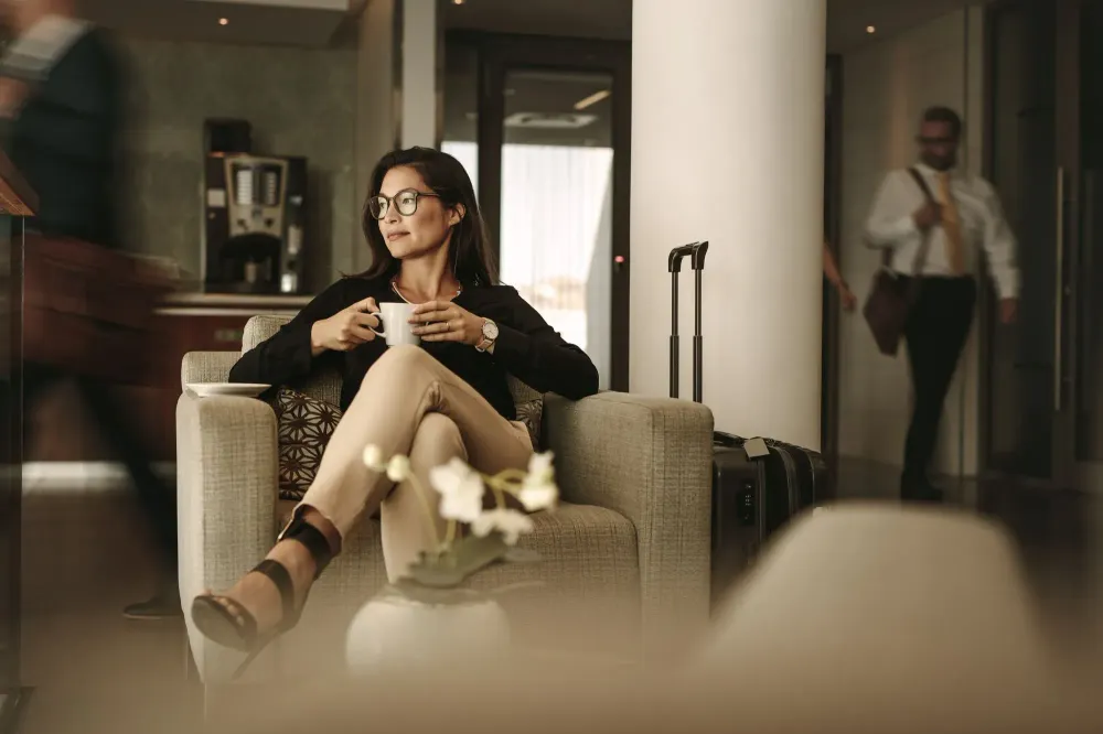 woman in priority pass airport lounge drinking coffee